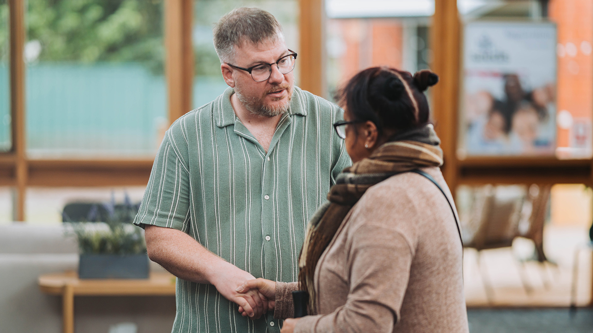 friendly pastor shaking persons hand